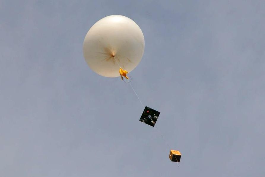 Tell me, what does the weather balloon measure in the sky? Discover the atmospheric conditions it is recording.